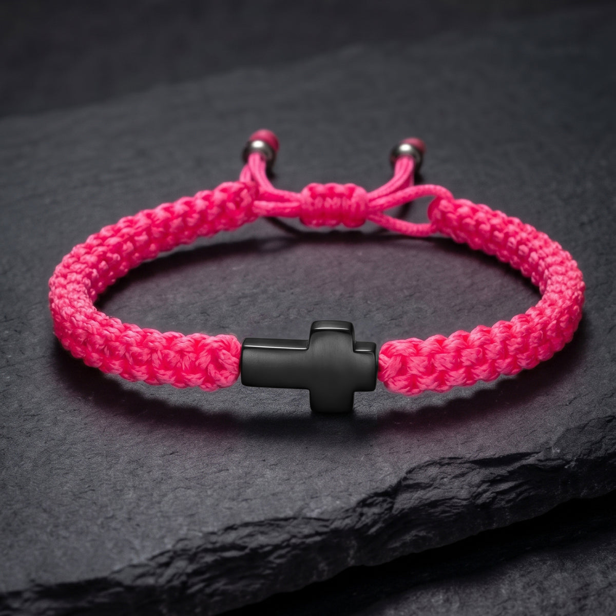 CRUZ. PULSERA TRENZADA ROSA NEON CON CRUZ NEGRA